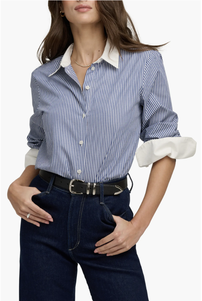 A close-up of a classic blue-and-white striped button-up shirt with a contrasting white collar, tucked into dark-wash denim jeans and secured with a black leather belt.