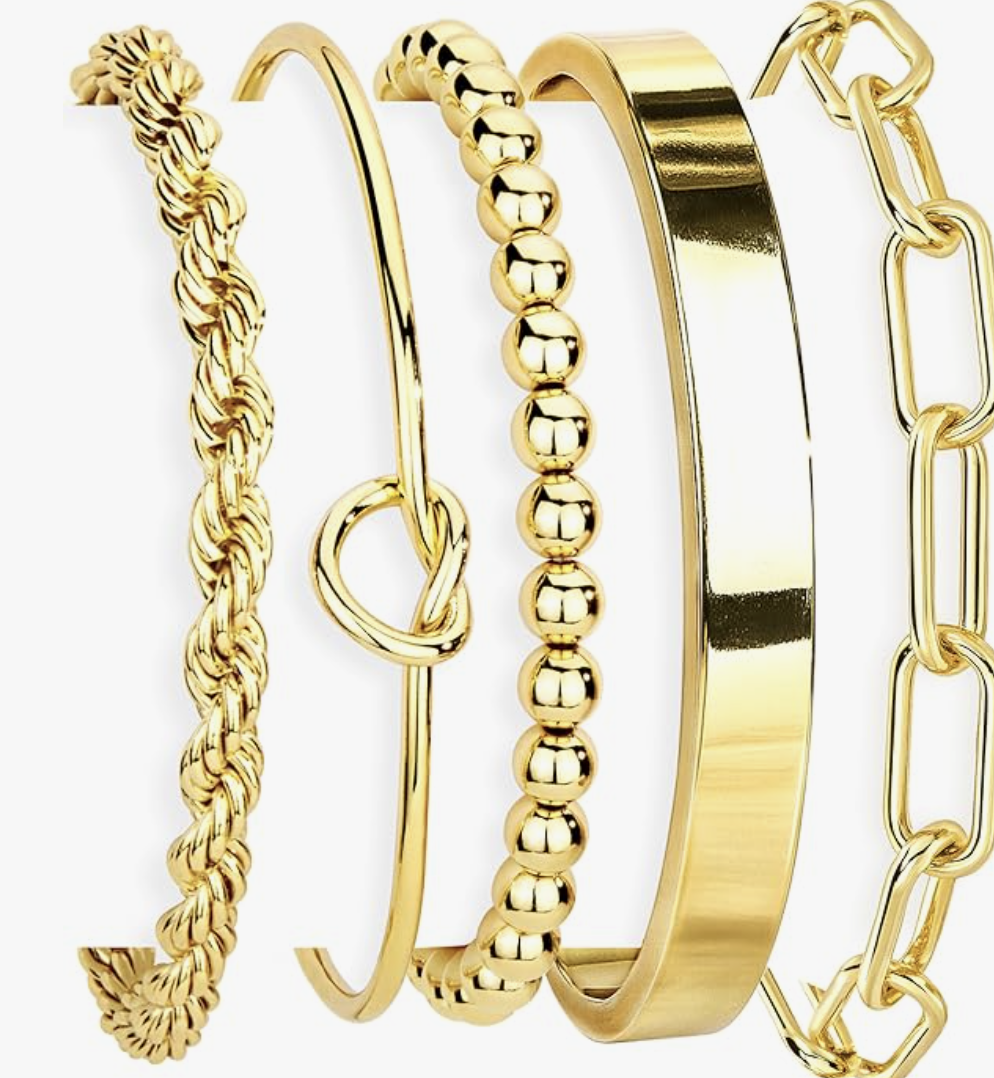 A set of three 14K gold-plated stackable cuff bracelets including a twisted rope design, a classic paperclip chain, and a sleek flat bangle, styled as a tarnish-free jewelry essential for women in their 50s.