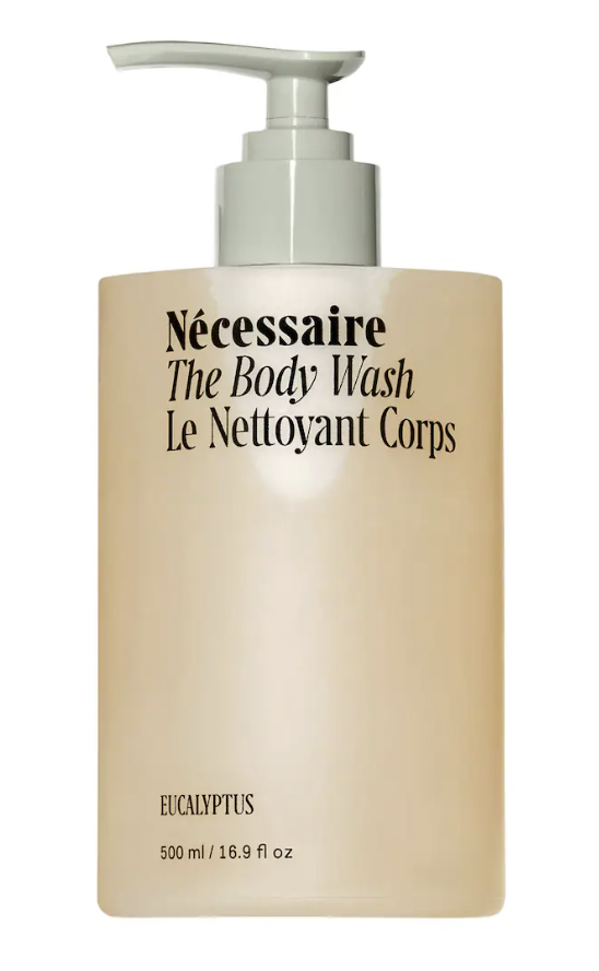 A tall, minimalist tan bottle of Nécessaire The Body Wash in the Eucalyptus scent with a silver pump dispenser.