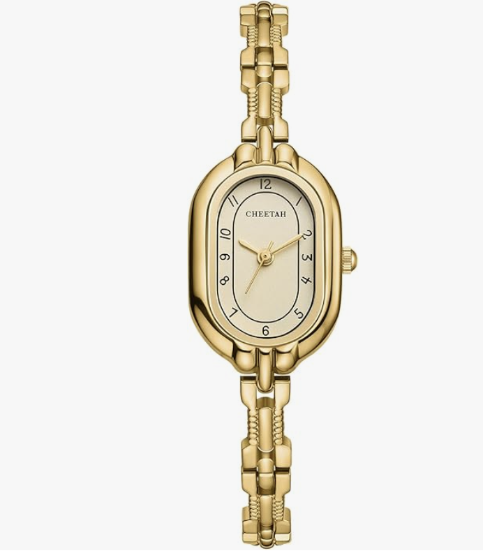 A dainty gold-tone CHEETAH bangle watch with an oval face and vintage-style numeral dial, styled as an elegant accessory for women over 60.
