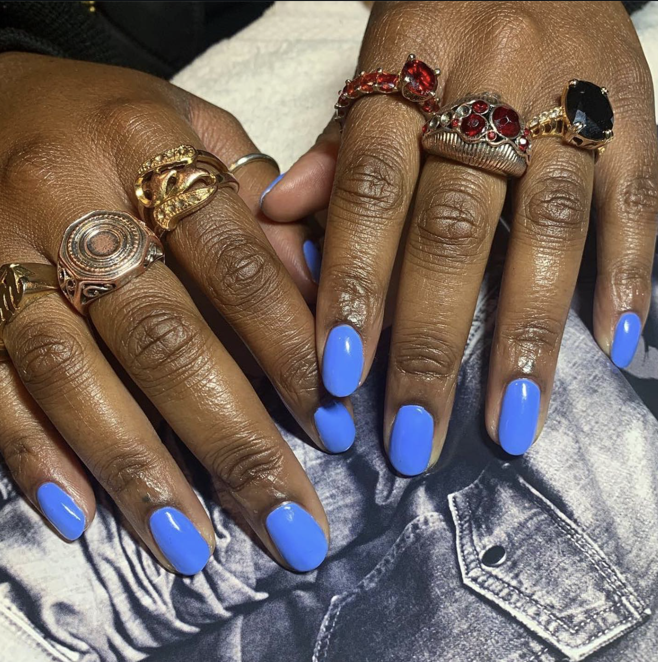 Short, natural round nails painted in a solid, high-gloss vibrant electric cobalt blue polish