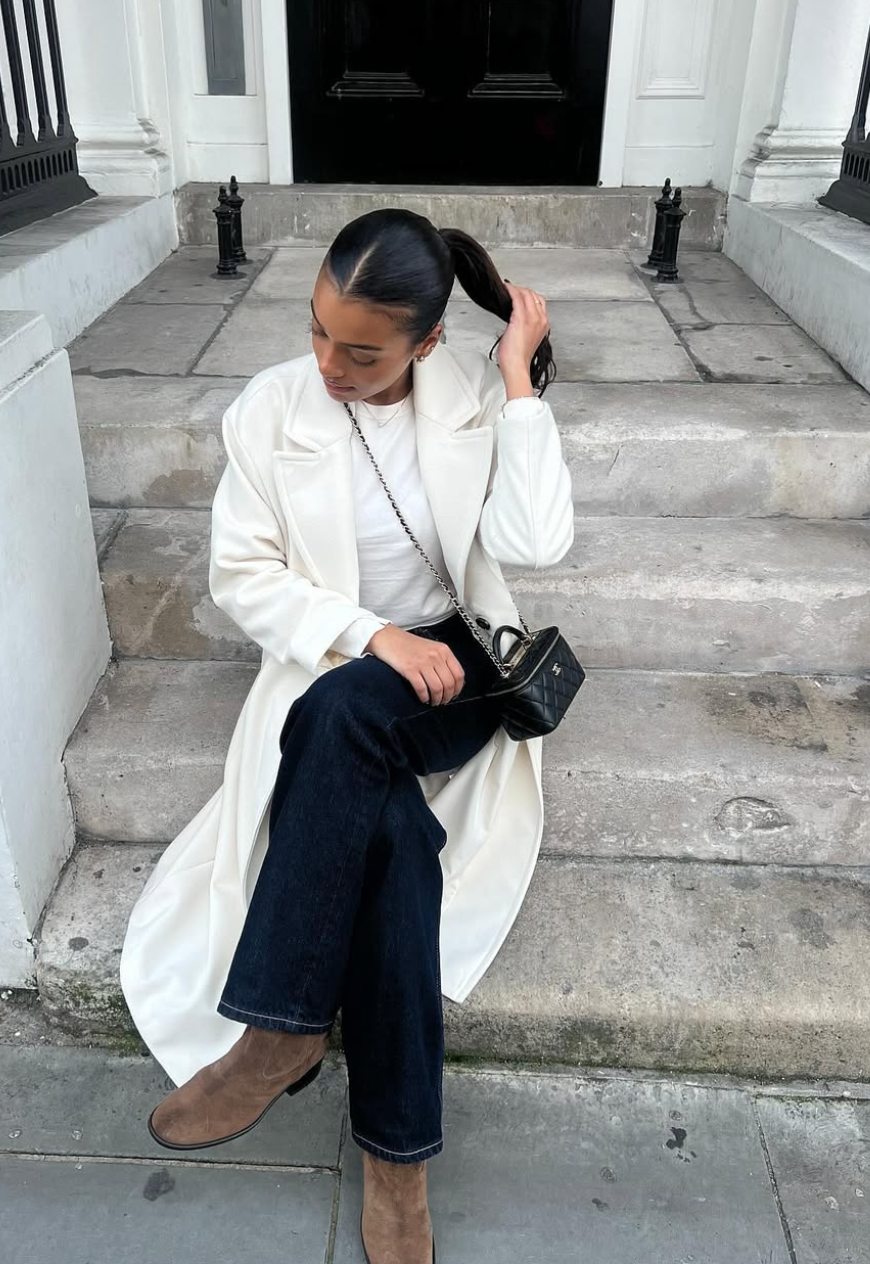 woman wearing a white trench coat and white tshirt with jeans