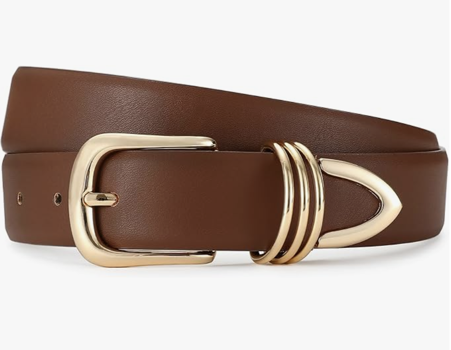 A close-up of a smooth cognac-colored leather belt with a polished gold triple-ring buckle, styled as a timeless investment accessory for a capsule wardrobe.