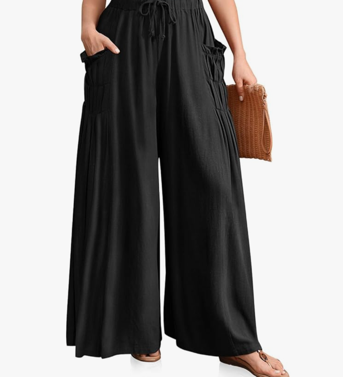A pair of black TARSE linen palazzo pants with an elastic drawstring waistband and pleated wide-leg detail, styled with a small brown leather handbag.