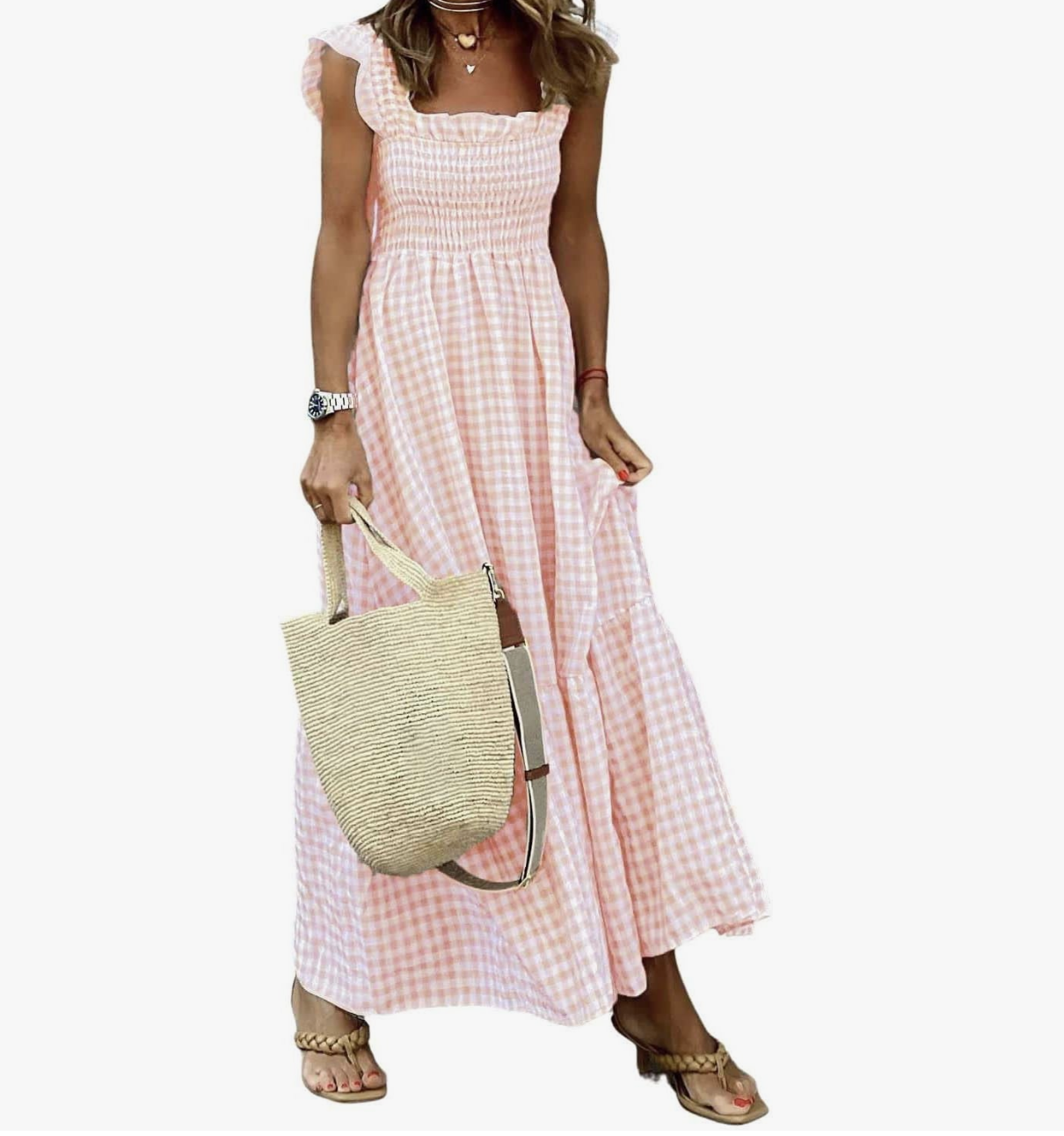 A woman wearing a khaki and white plaid maxi dress with a smocked bodice and spaghetti straps, styled with a small straw bucket bag and tan sandals.