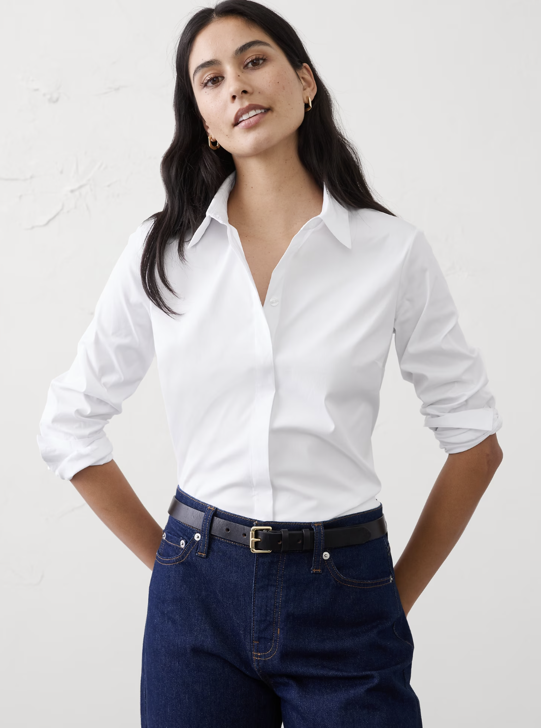 "Classic style wardrobe essential: A crisp white tailored button-up shirt showing clean lines and a structured fit, perfect for a timeless and put-together professional look."