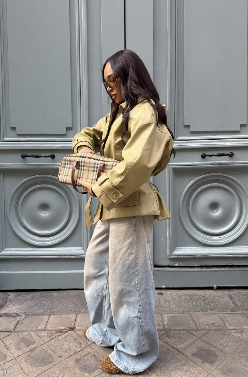 A fashion editor-inspired casual look featuring relaxed wide-leg jeans paired with sporty black slides, demonstrating a comfortable yet intentional silhouette, styled by @bygigivassallo.