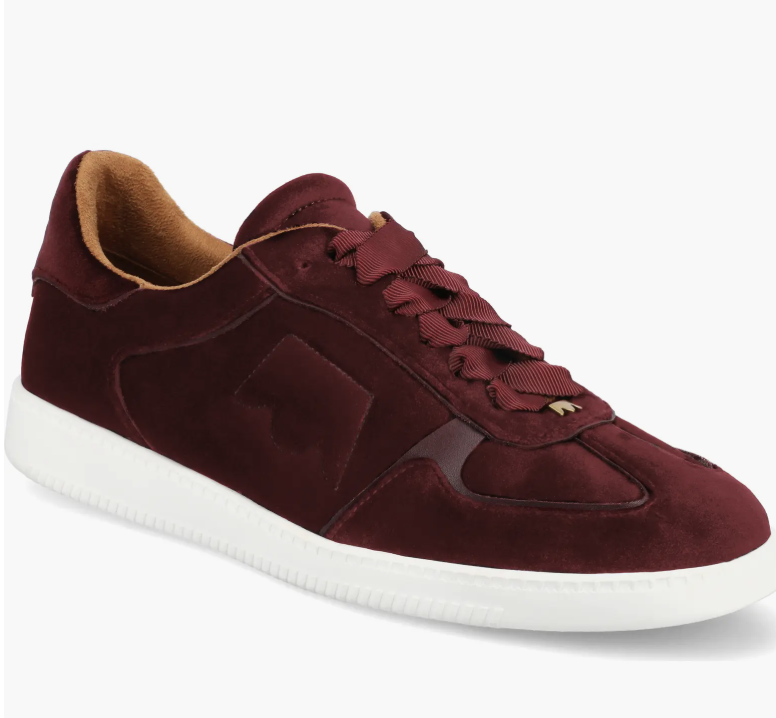 A pair of rich burgundy velvet Birdies The Jay sneakers with wide grosgrain ribbon laces, styled as elegant and professional work sneakers for the office.