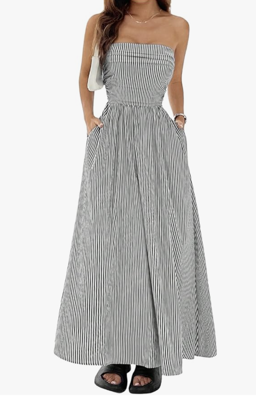 A woman wearing a black and white striped strapless maxi dress with a high-waisted cut to hide a long torso and create the illusion of longer legs.