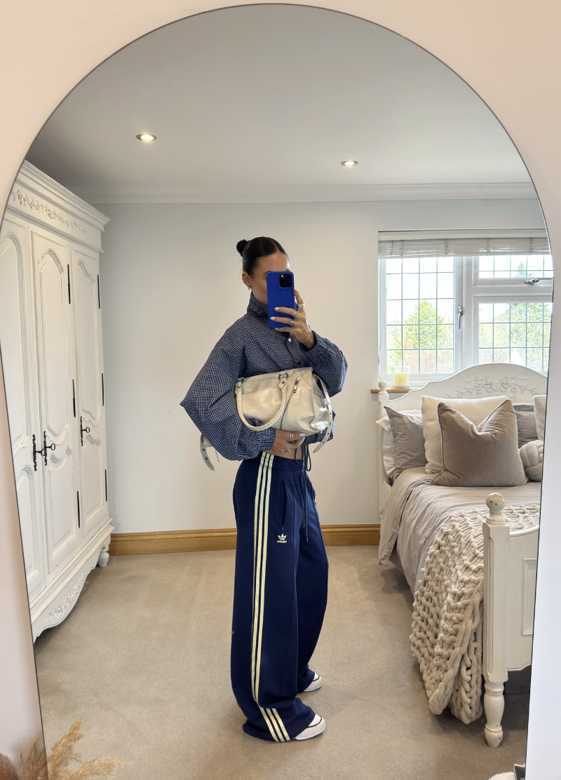 A side view of the Adidas Firebird Oversized AOP Denim Pants in a bold brown and tan leopard print, featuring the signature three stripes and a wide-leg silhouette for a maximalist Sportif Luxe outfit.