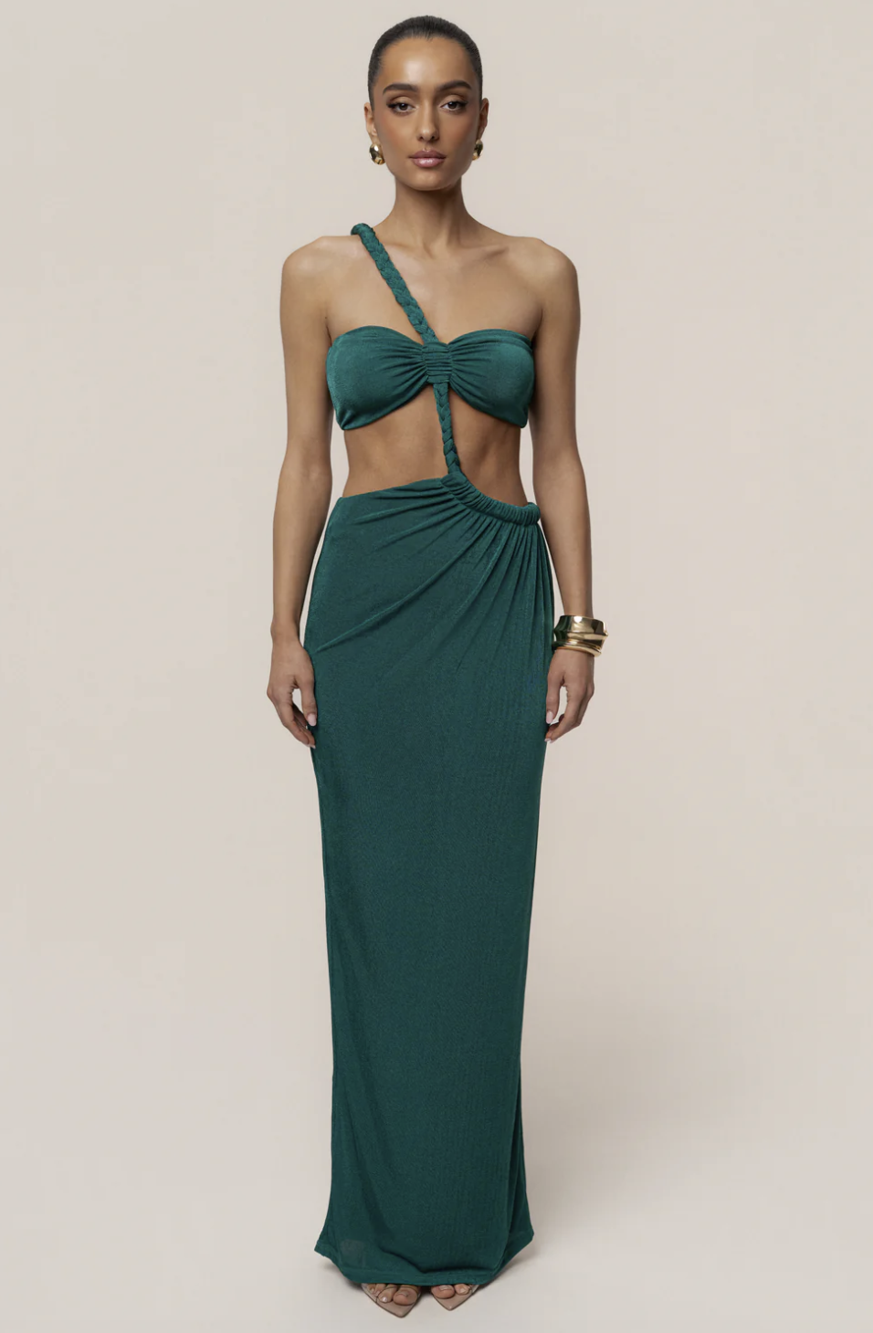 A woman wearing the deep emerald JLUXLABEL Green Ema One Shoulder Maxi Dress with a braided strap and side cutout, styled for a luxury Mediterranean vacation.