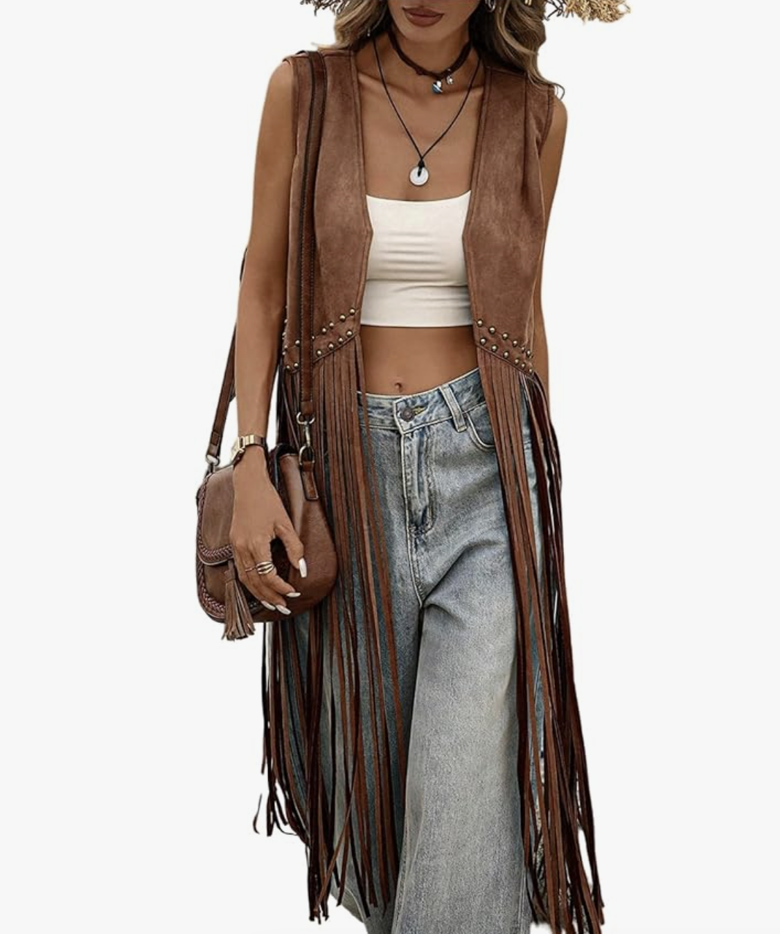 A woman wearing a long chocolate brown suede vest with floor-length fringe, styled over a black top and light-wash denim jeans