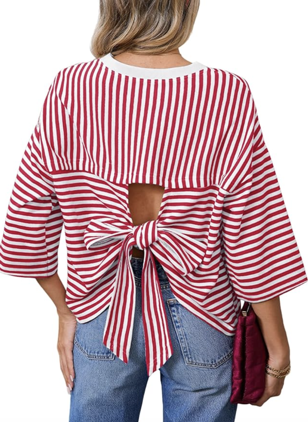 Fashion editor wearing a red and white horizontal striped boatneck top with an open-back bow detail, styled with black wide-leg trousers for a 2026 outfit formula.