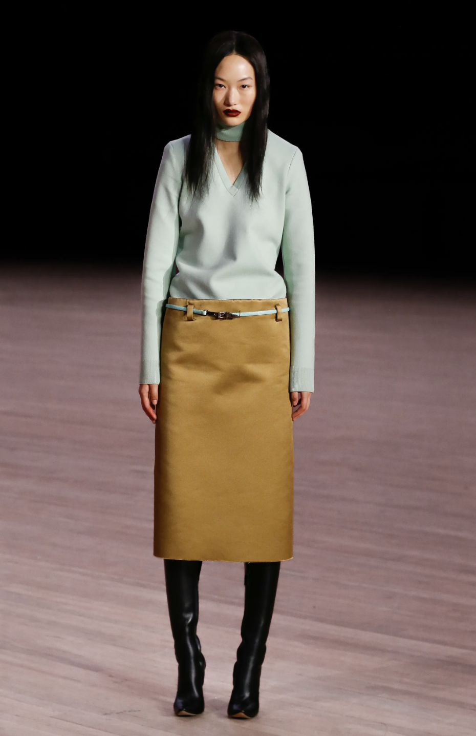 A model on the Marc Jacobs Fall/Winter 2026 runway wearing a bold color-blocked outfit in mustard yellow and bright pink, illustrating the season's daring duo trend.