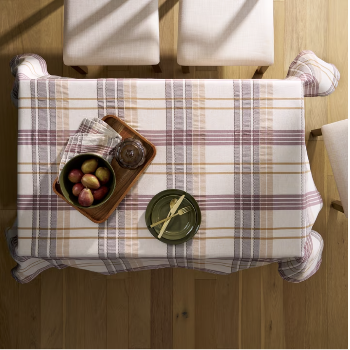 Friendsgiving dining table dressed in a plaid tablecloth with simple fall place settings