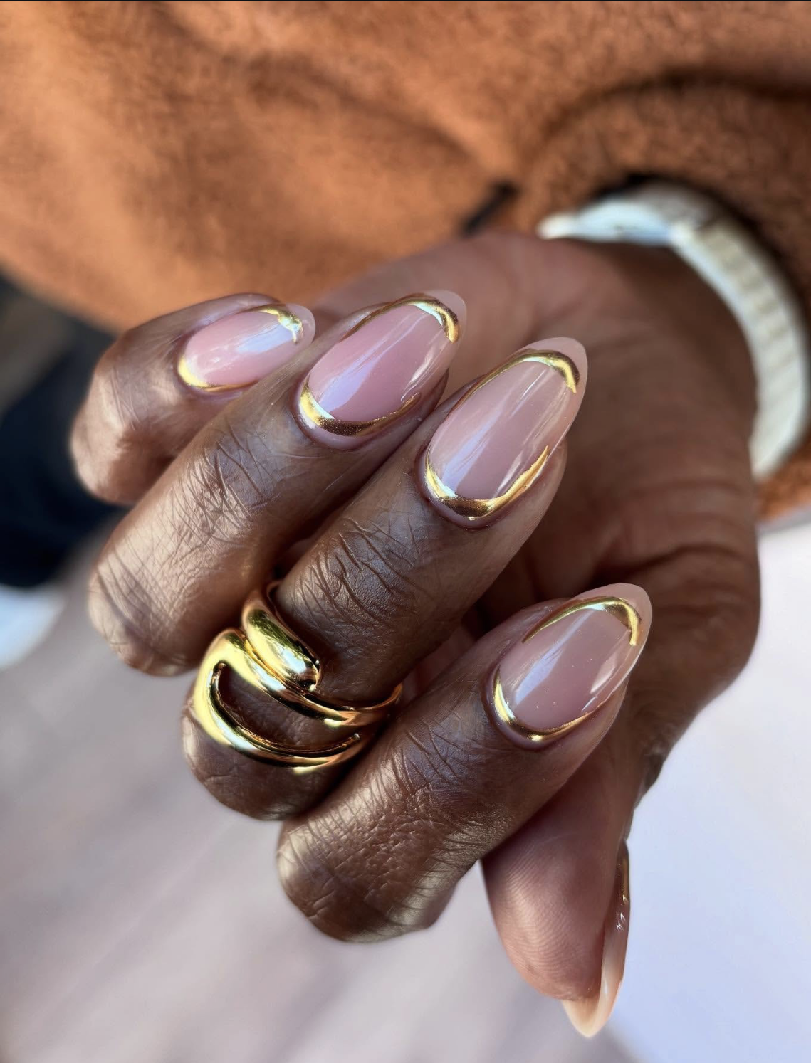 Taupe manicure with delicate gold accents on short rounded nails