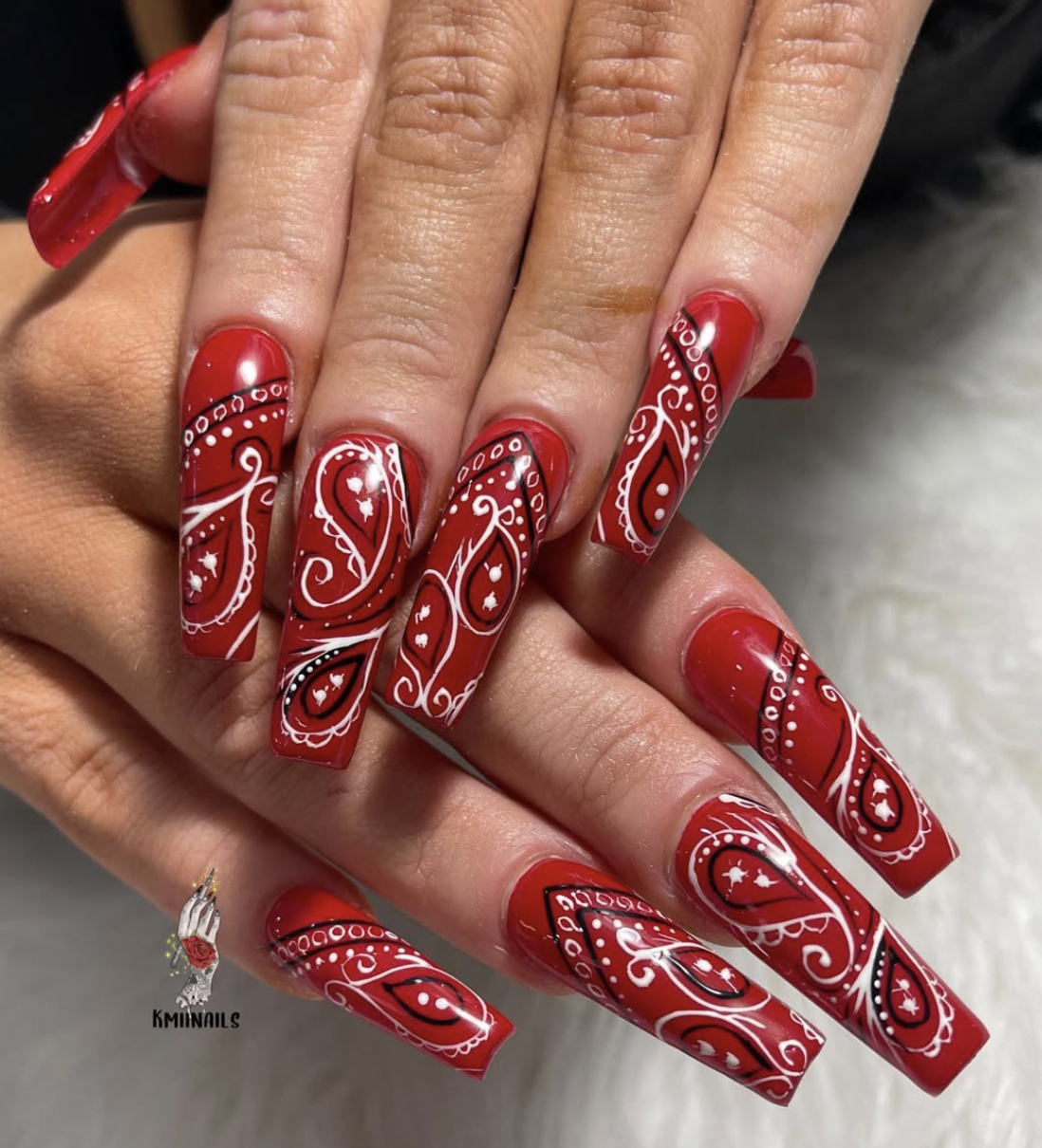 Long, square-shaped acrylic nails painted with an intricate, vibrant red-and-white classic Americana bandana paisley pattern.