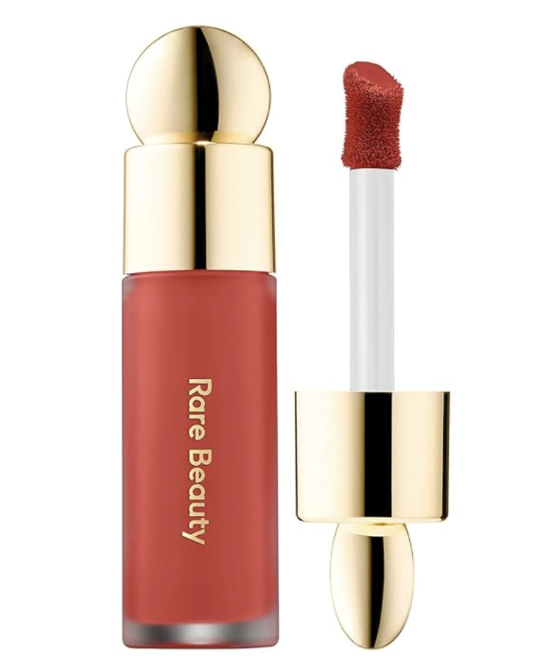 Rare Beauty Soft Pinch Liquid Blush in the shade 'Love,' featuring the iconic gold circular cap and a heart-shaped applicator tip with a vibrant terracotta-red smudge.