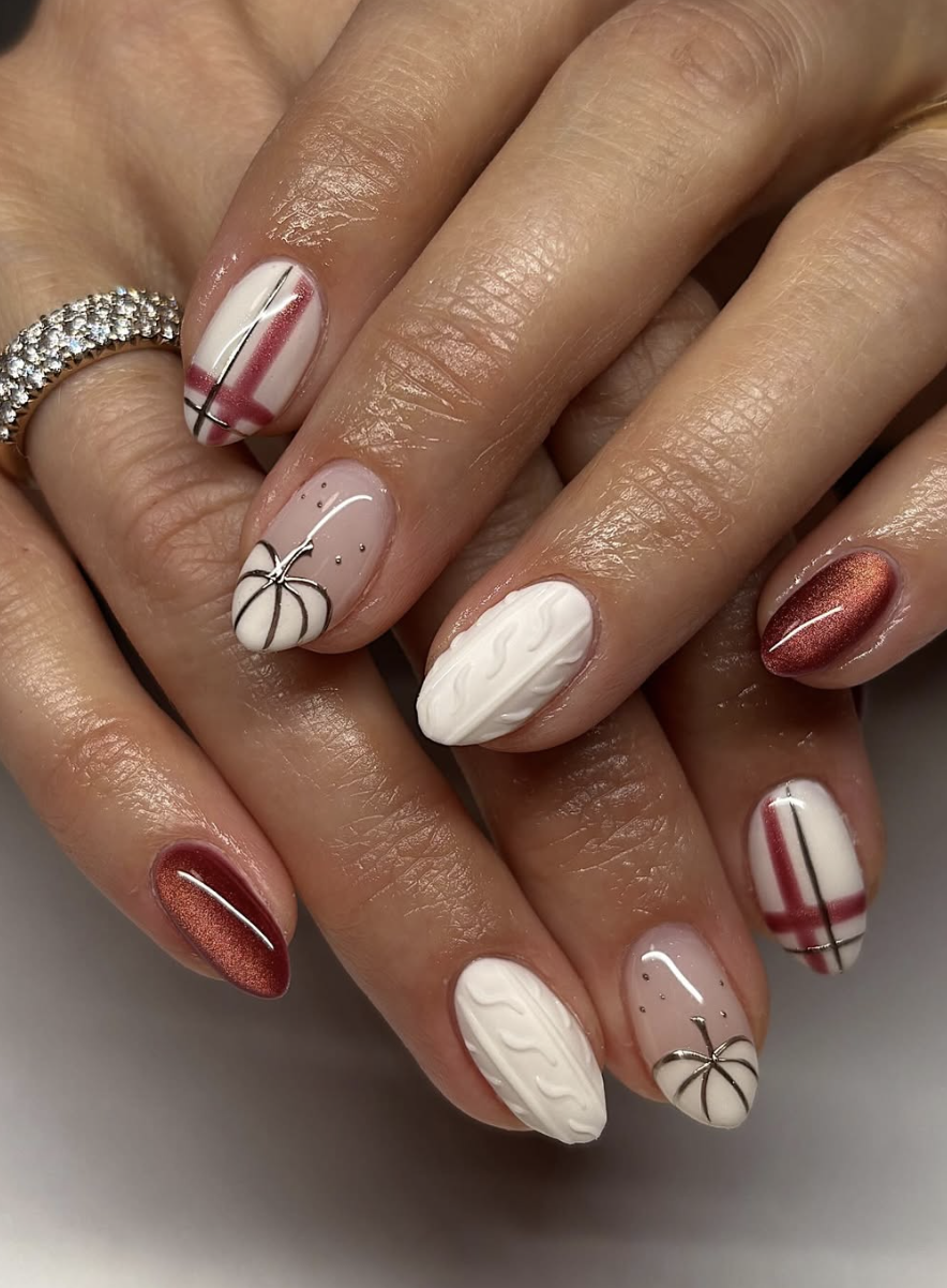 Cream cable-knit sweater nails with a small orange pumpkin accent