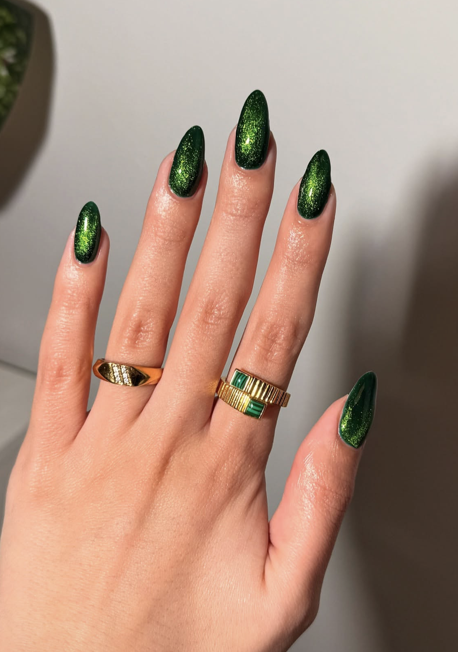 Forest green cat-eye Christmas nails with a reflective magnetic finish