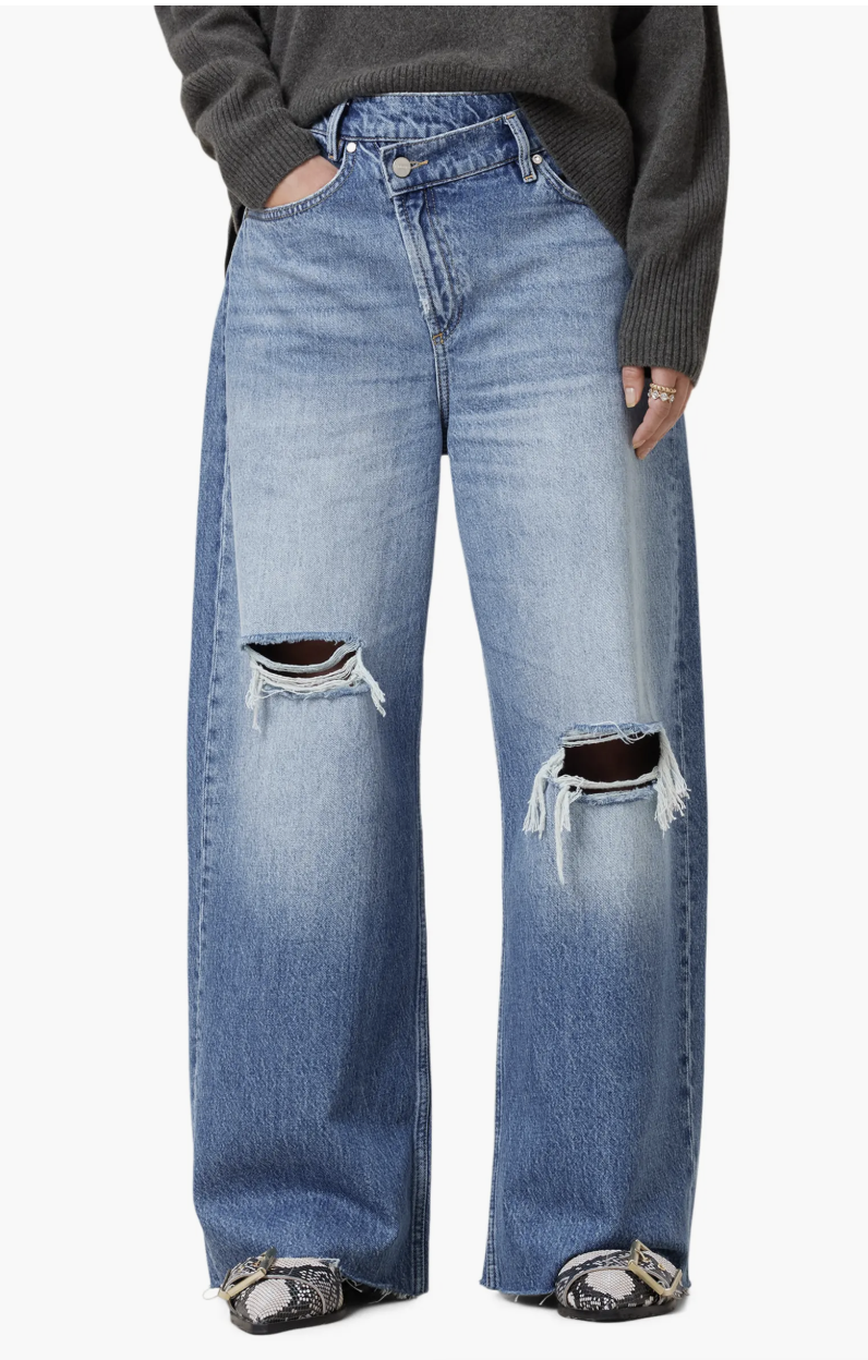 A product shot of light-wash AllSaints Aki Crossover Ripped Wide Leg Jeans styled with snake-print pointed-toe boots to create a high-contrast, structural look.