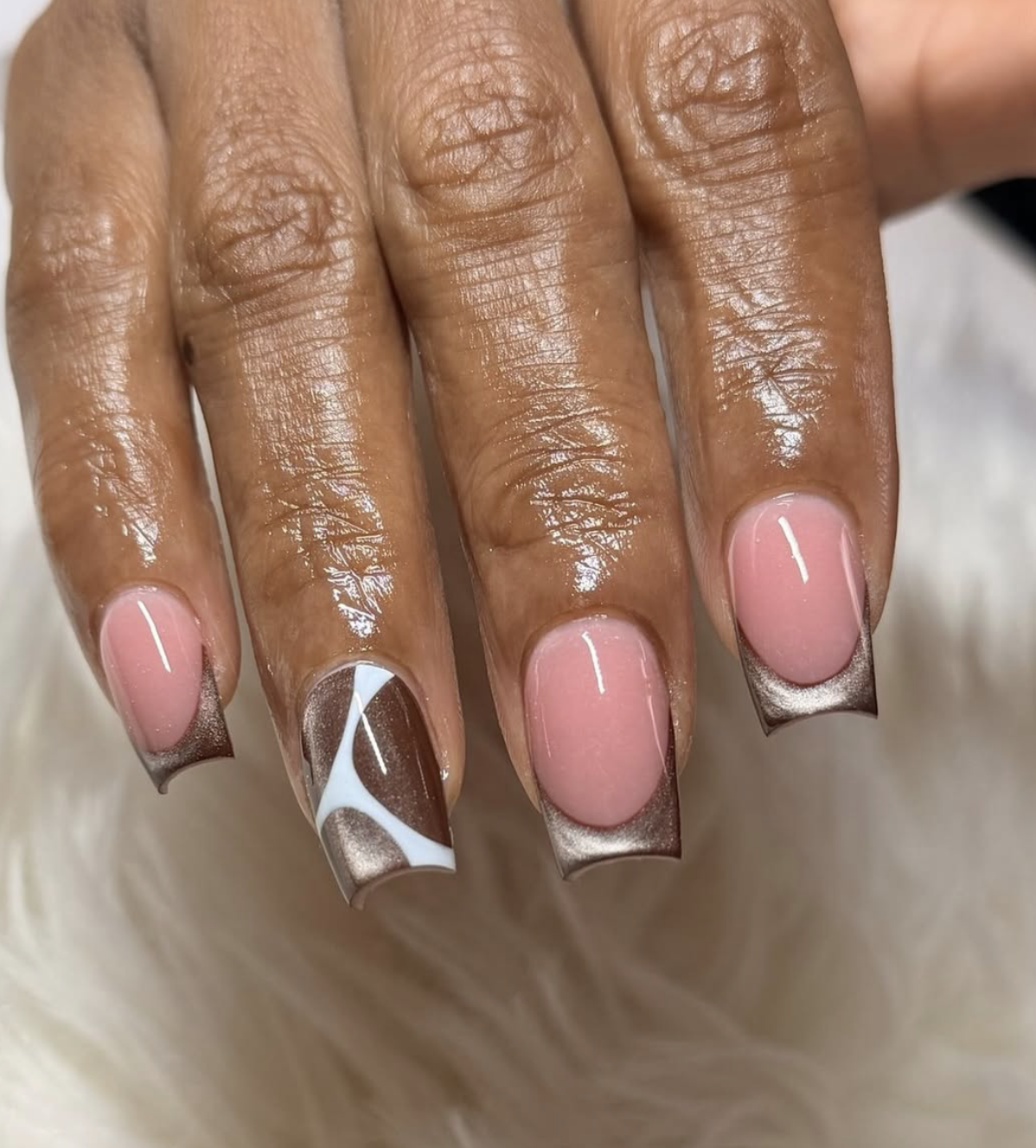 double caramel french tips manicure photographed close up on hands.