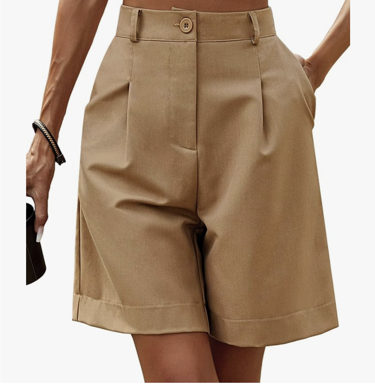 A close-up of a woman wearing khaki high-waisted pleated Bermuda shorts from Amazon with a wide-leg fit and cuffed hem.