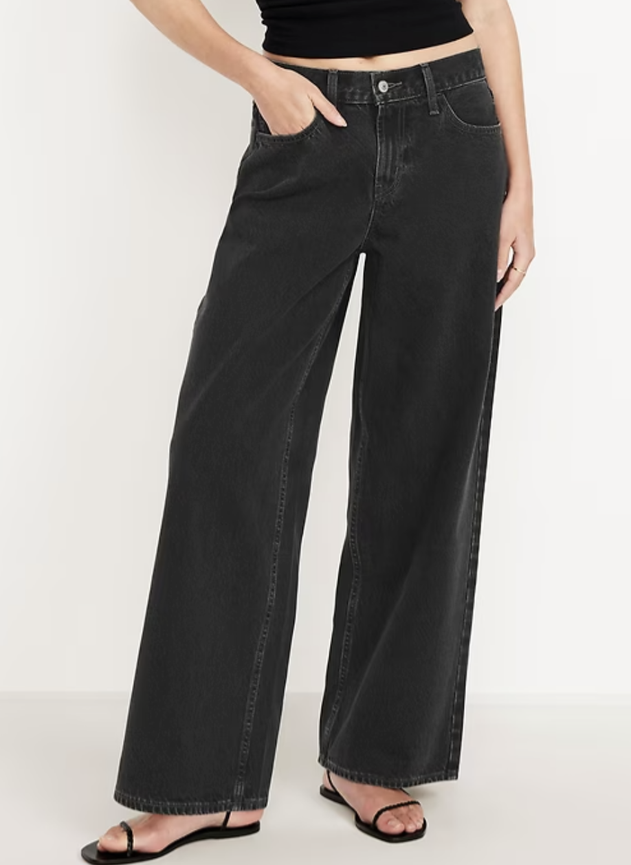 Model wearing Old Navy Mid-Rise Wow Baggy Wide-Leg Jeans in a dark wash, paired with strappy sandals, showing the structured baggy fit that adds volume to the hips for rectangle and athletic figures.