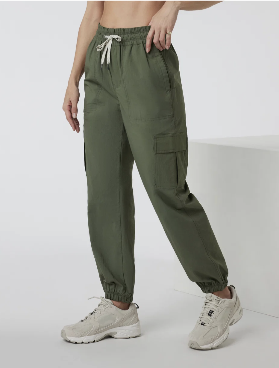 Olive green Vuori Birch Jogger styled with beige sneakers