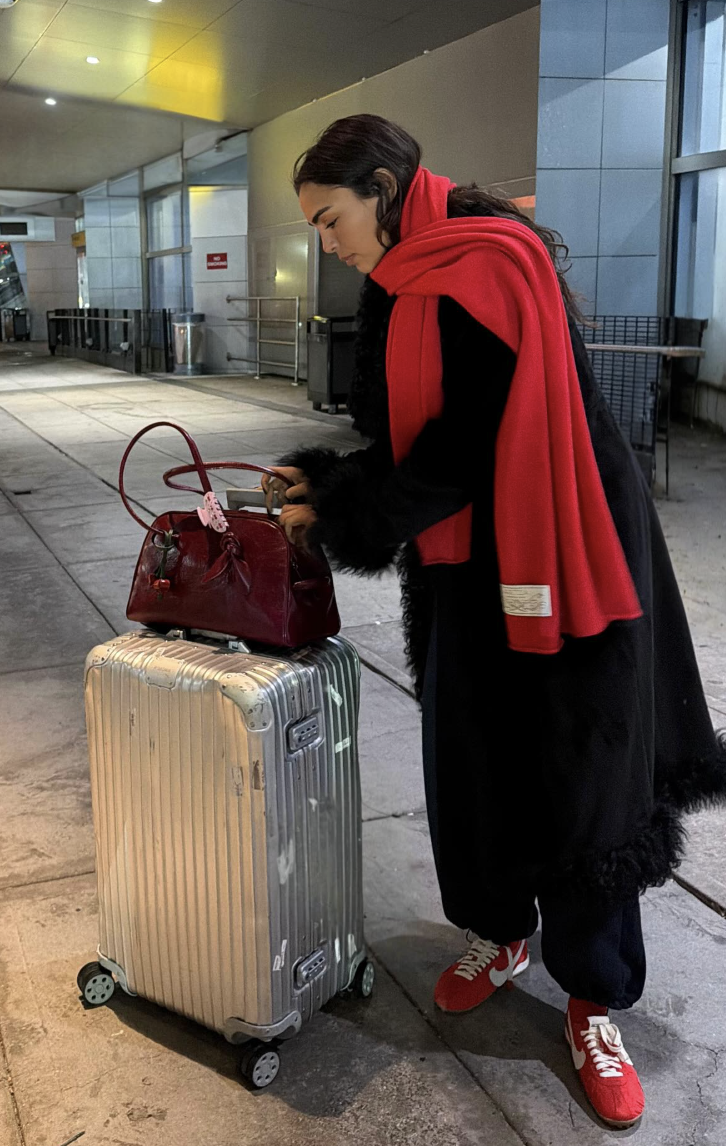 A black outfit with a bright red scarf.