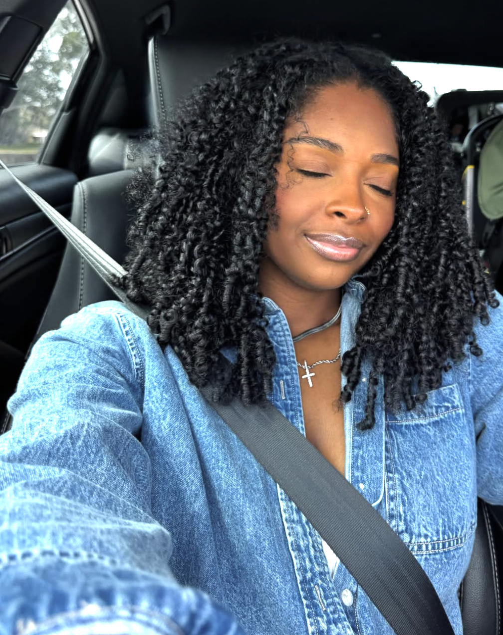 A woman with a square face shape wearing a full, voluminous wash-and-go with defined curls that create a soft, organic contrast against a strong jawline