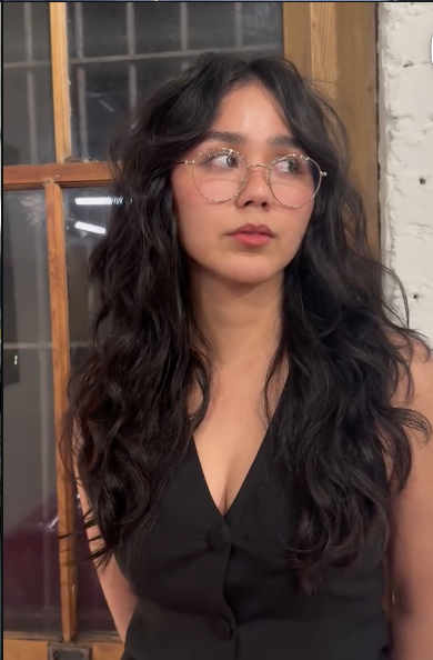 Woman wearing long curtain bangs on wavy hair with soft face-framing movement