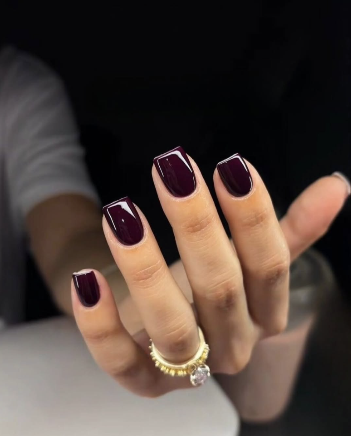 Almost-black plum October nails with a glossy deep purple finish