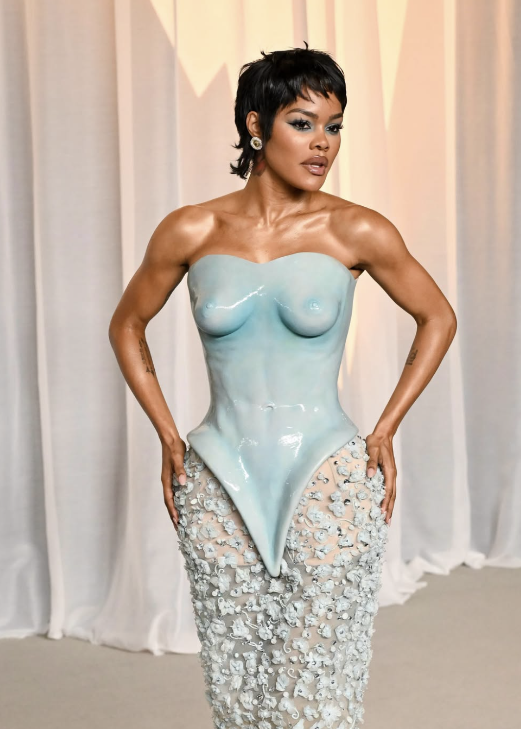 Teyana Taylor at the 2026 Academy Museum Gala in a Schiaparelli couture gown with a sculpted pale blue glazed bodice and an embellished floral skirt.