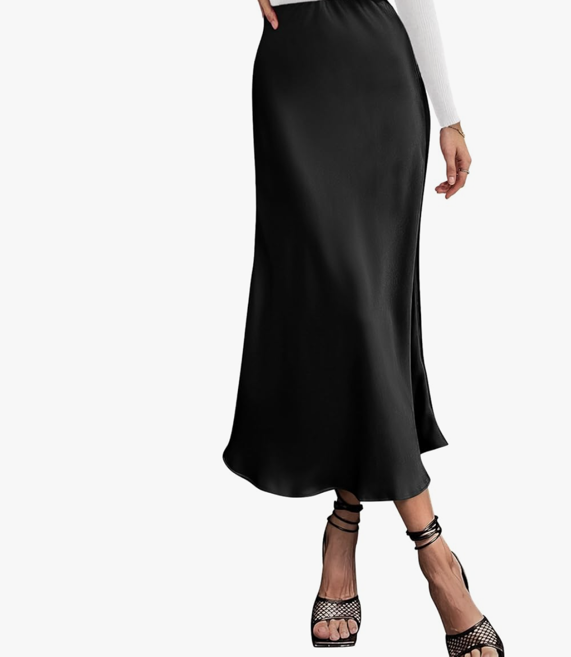 Close-up of a woman wearing a black satin A-line midi skirt, styled with black mesh strap heels.
