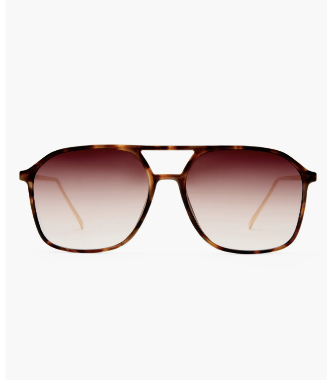 Woman wearing AIRE Cusp aviator sunglasses with a tortoise shell frame and brown gradient lenses, a top 2026 eyewear trend.