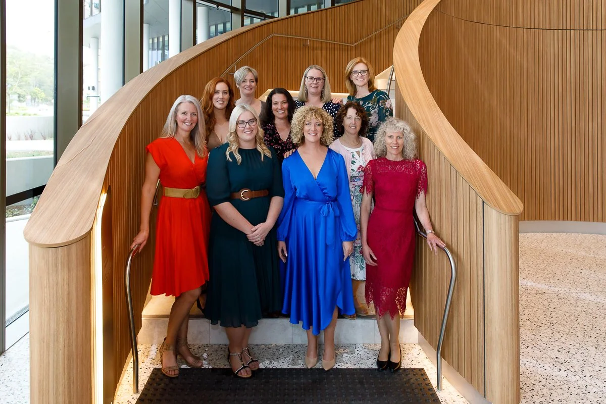A team of businesswomen standing on a sprial staircase in the conference centre at the Pullman Hotel in Penrith during a branding session