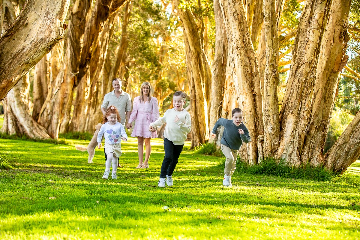 A family running in the afternoon sun at Centennial Park in Sydney's eastern suburbs for a family photoshoot