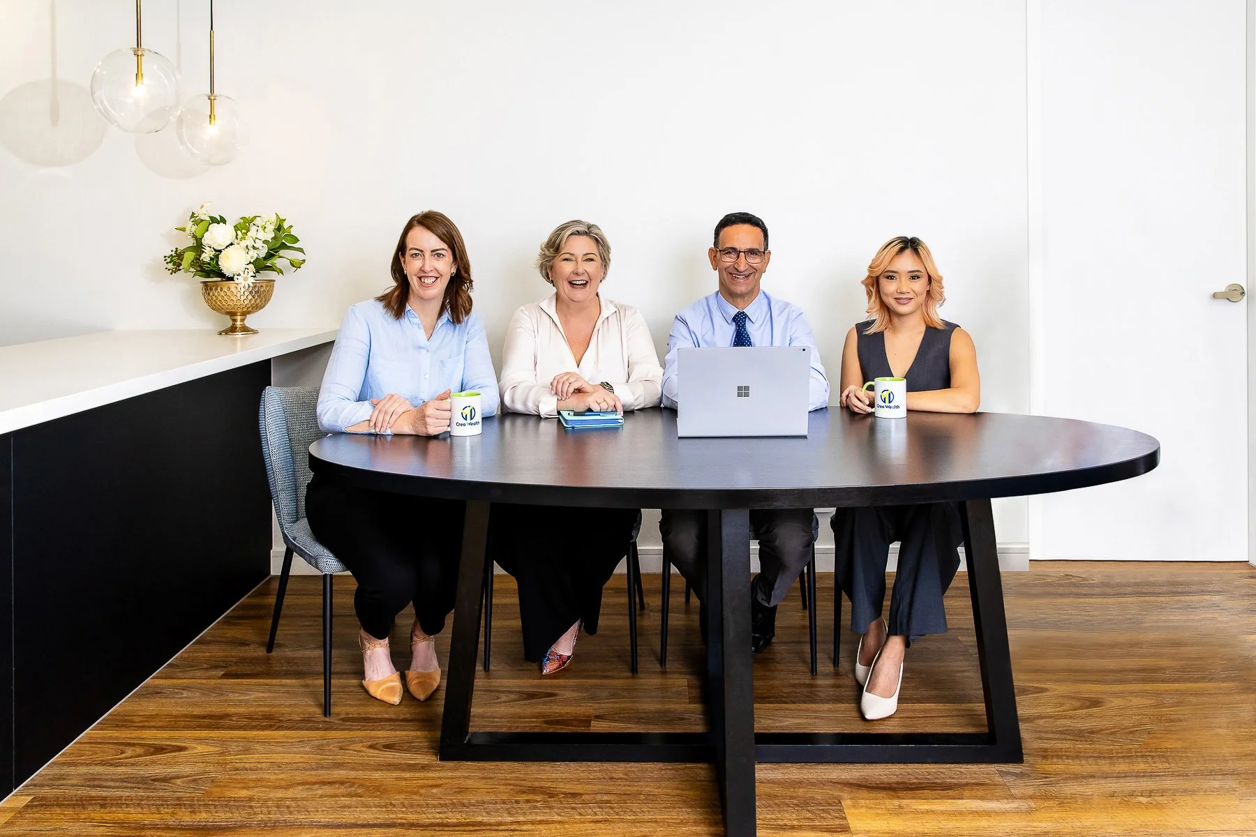 A team sitting around a table in a room in the Astina Suites in Penrith during a branding photoshot