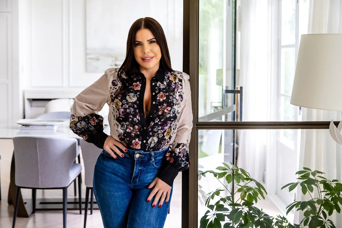 Woman in jeans and flower top leaning on a door frame in a studio in Galston in the Hills District in a personal branding session