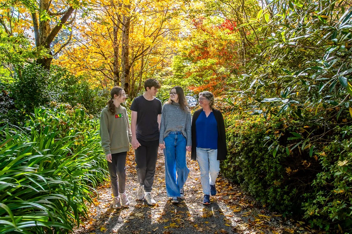 A family walking together in the autumn colours of Bebeah Gardens during a family photoshoot
