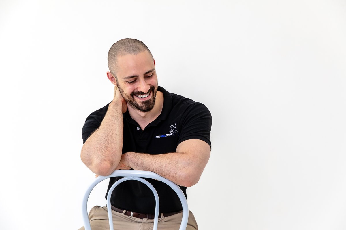 Young man sitting on a chair looking away laughing