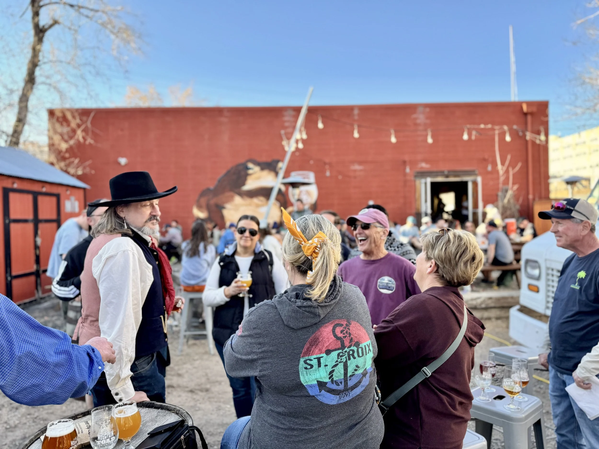 A group gathered around a tour guide laughing at a story.