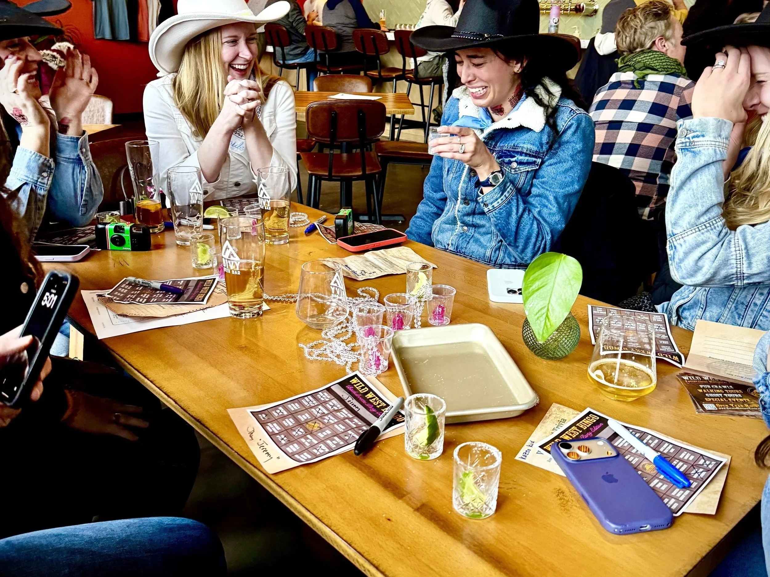 Partiers around a table with bingo cards.