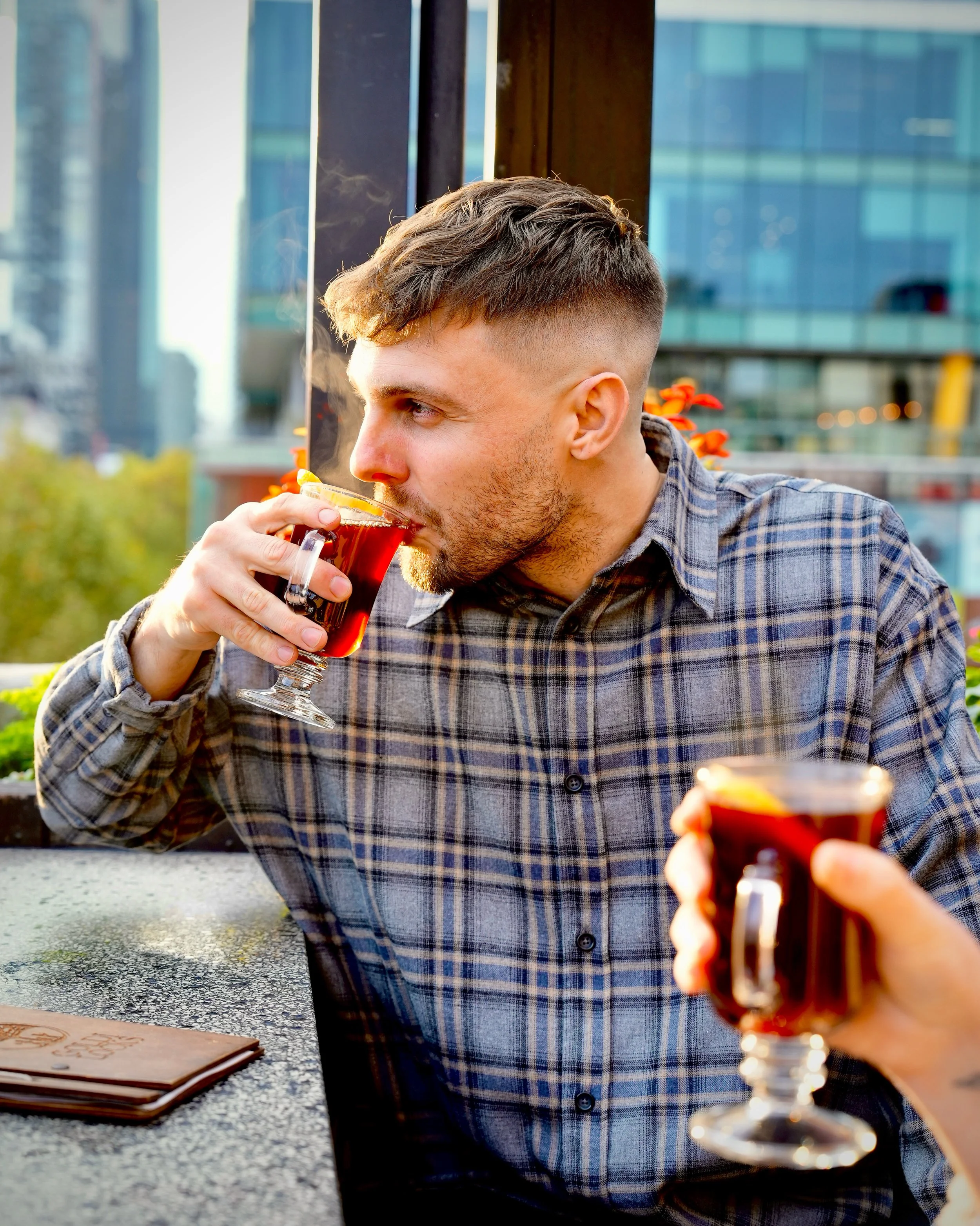 Guest enjoying mulled wine at Goldilocks Rooftop Bar in Melbourne CBD as part of the Winter Warmers menu.
