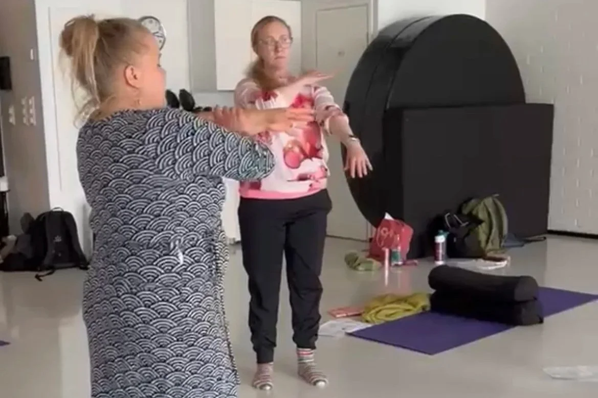 Osteopaatti Salla kurkistaa kuusen takaa.