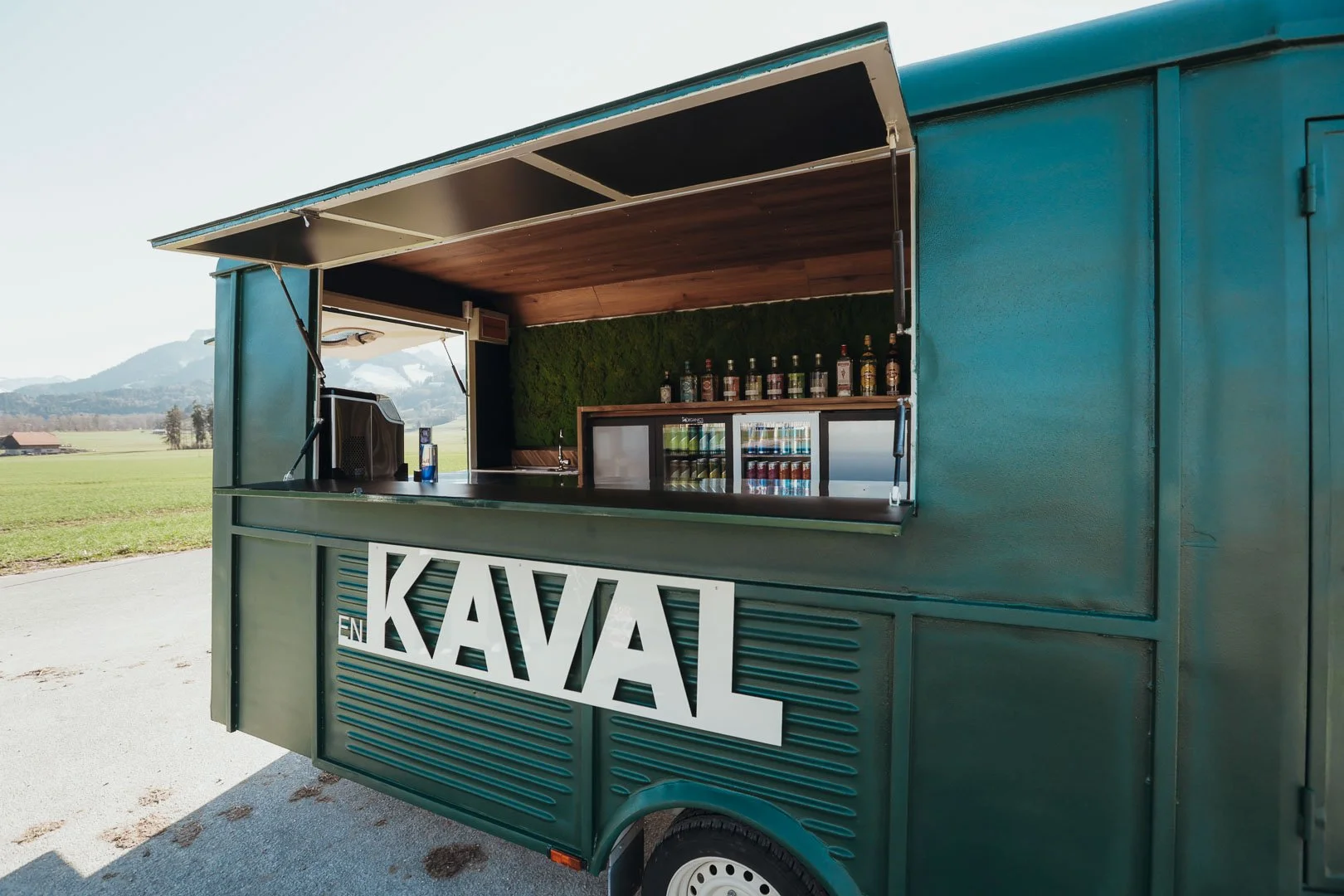 En Kaval est une roulotte vintage transformée en bar itinérant disponible à la location pour vos événements dans toute la Suisse. Un projet signé "La Kave" créé au coeur du canton de Fribourg