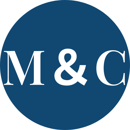 A circular logo with a dark blue background and white text that reads "M & C".