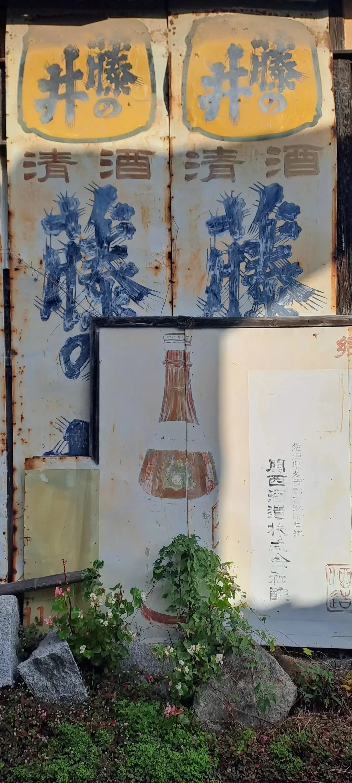 Japanese writing and painting on a metal panel.