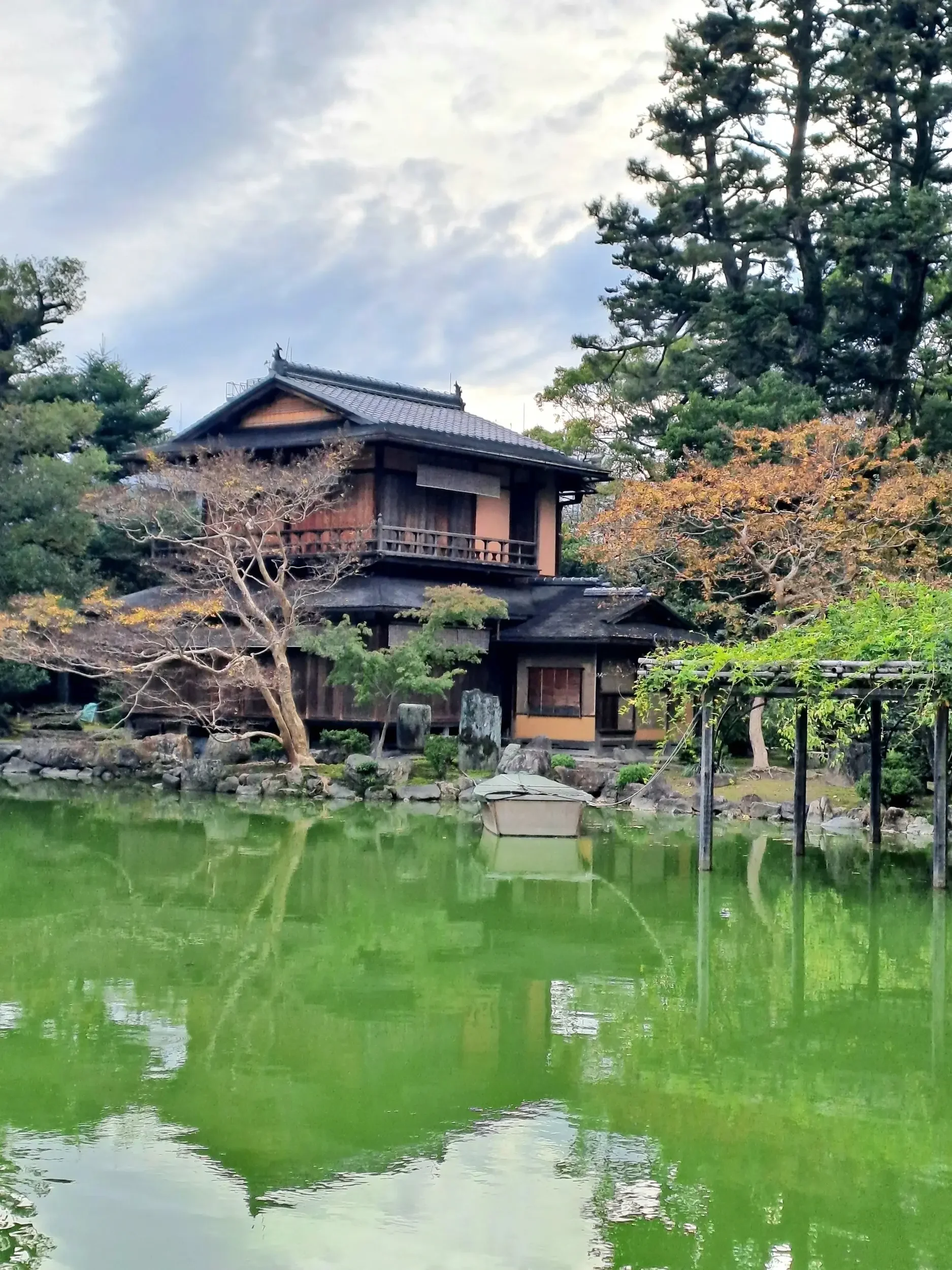 Traditional Japanese building with a lake and a boat.